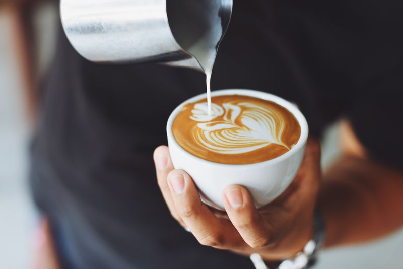 Cup of coffee on a table beside a window with street view